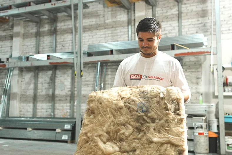 Colaborador de CIASA con un rollo de aislamiento en la bodega
